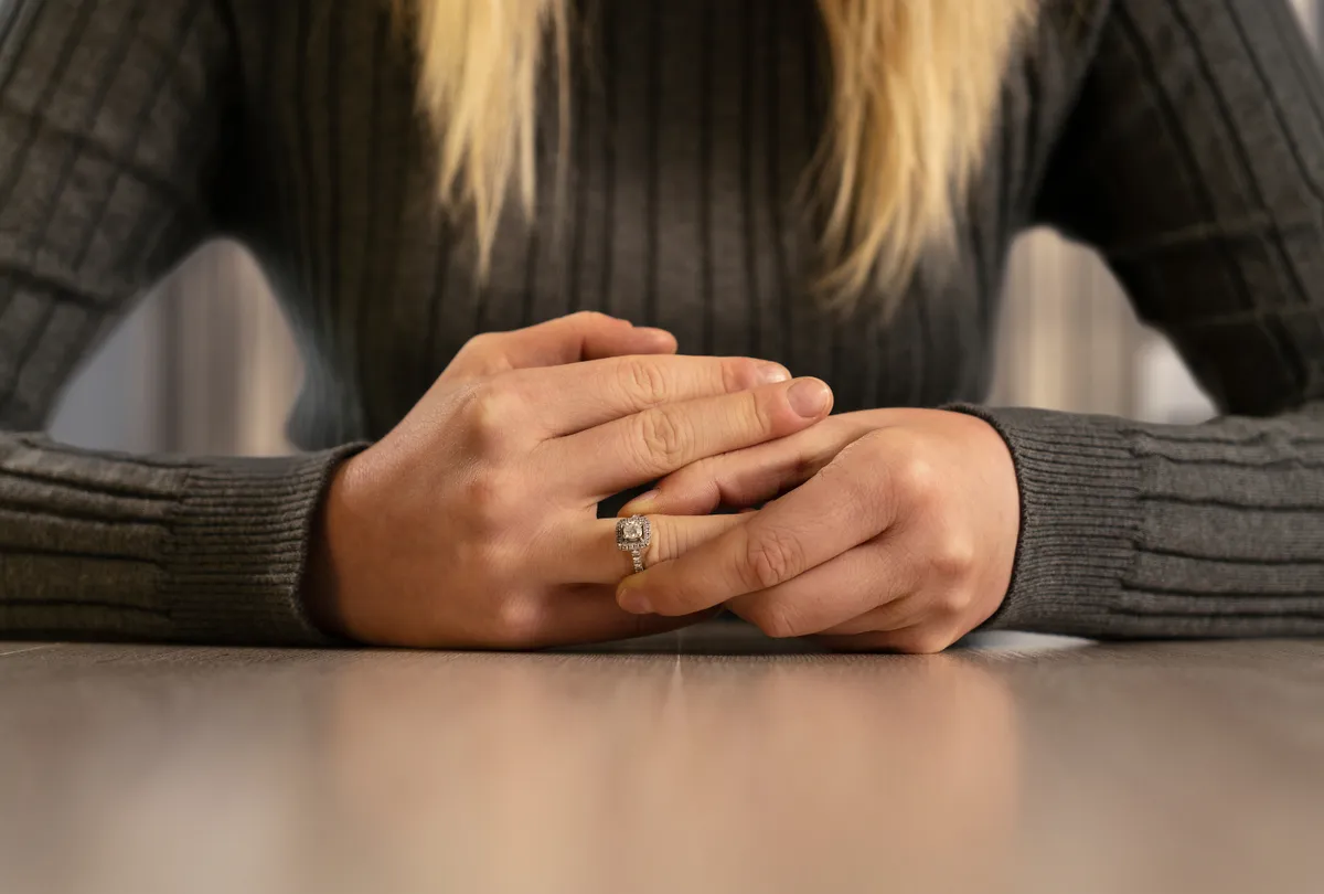A woman's hands removing a wedding ring